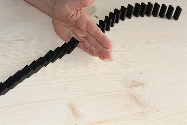 Hand und Dominosteine auf dem Tisch